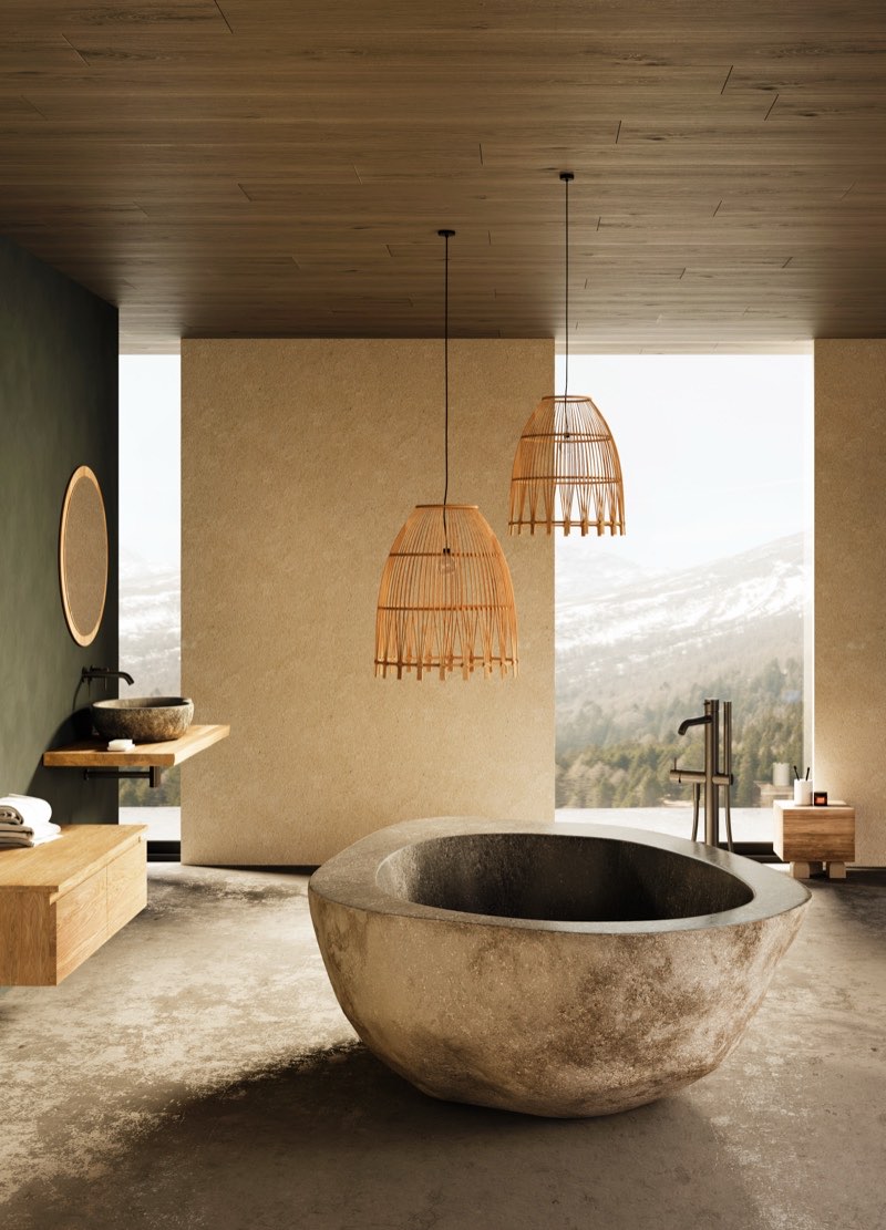 Freistehende Acquastone Badewanne aus massivem Flussstein in einem Bad mit Bergpanorama